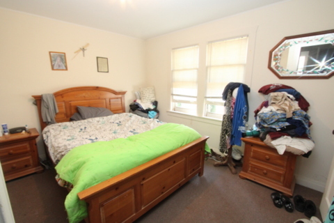 3311-3315 Waukegan Road McHenry, IL 60050 - Photo 14 of 16 a bed sitting in a bedroom next to a window with potted plants on dresser