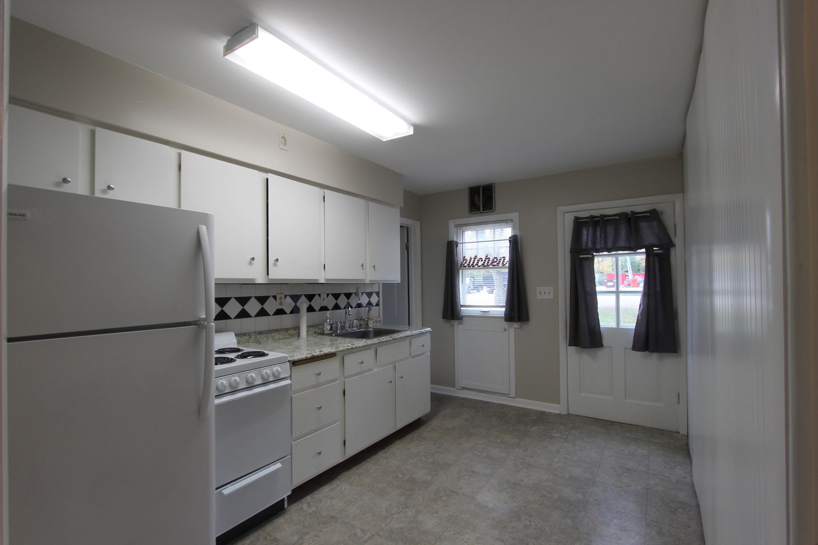 3311-3315 Waukegan Road McHenry, IL 60050 - Photo 4 of 16 a kitchen with cabinets and white appliances