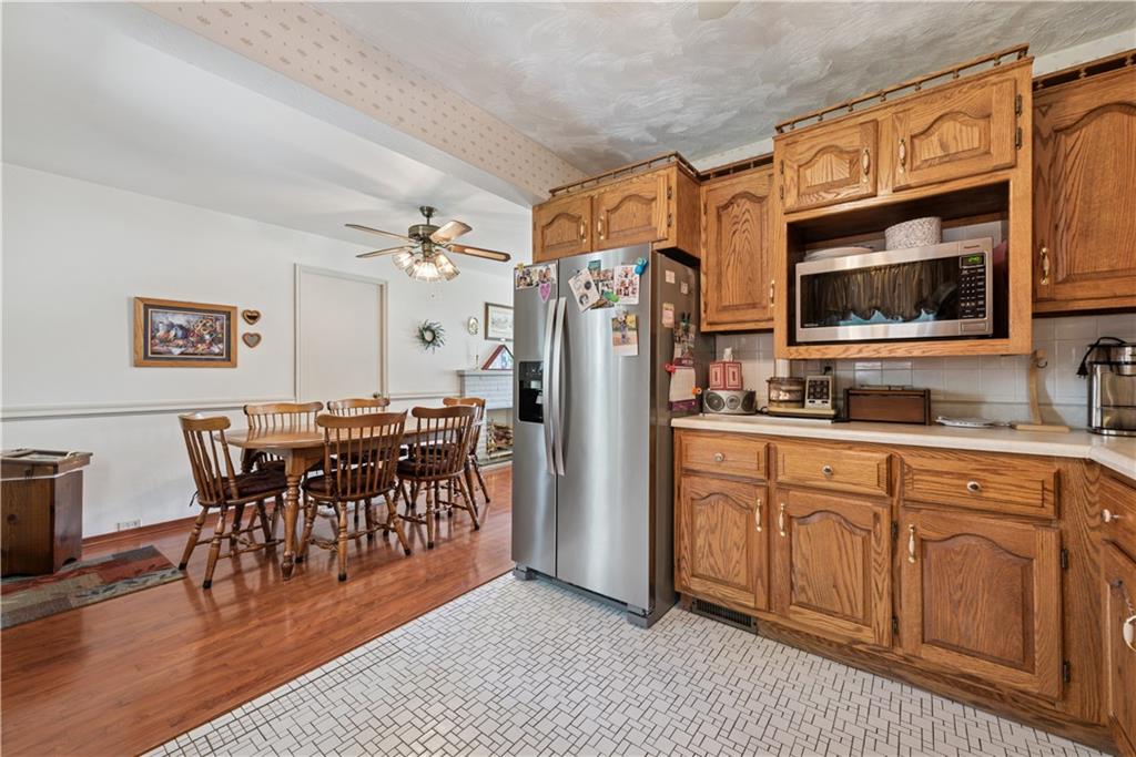 2122 Elizabeth Court Export, PA 15632 - Photo 16 of 35 a kitchen with stainless steel appliances granite countertop a refrigerator a stove a sink a dining table and chairs with wooden floor