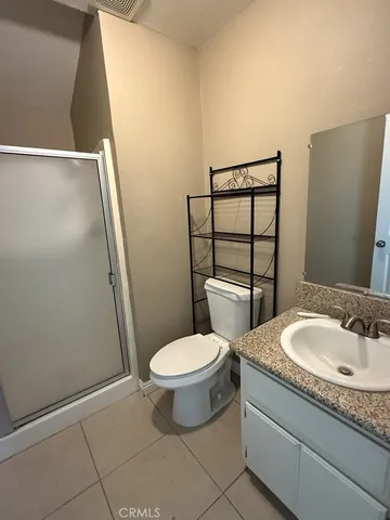 a bathroom with a granite countertop toilet and a sink