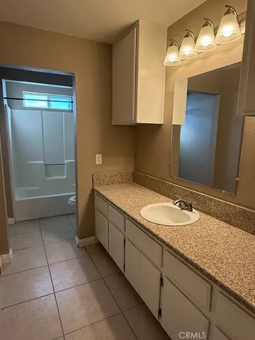 a bathroom with a granite countertop sink a mirror and a vanity