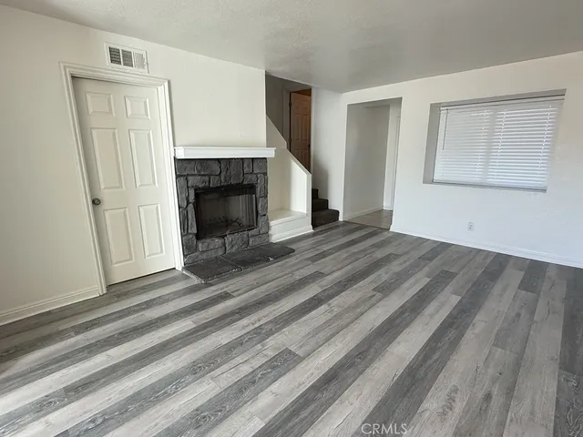 a view of a livingroom with wooden floor and a fireplace
