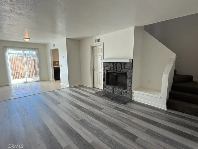 an empty room with wooden floor and fireplace