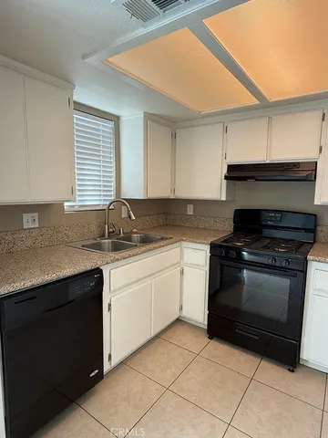 a kitchen with granite countertop a sink and a stove