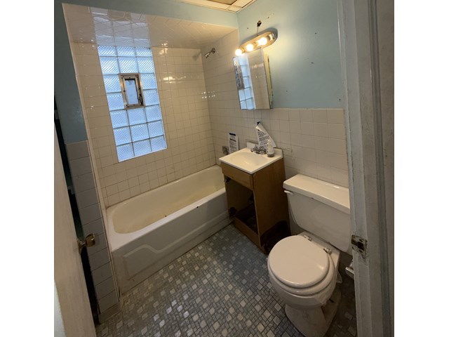 7514 South Rhodes Avenue Chicago, IL 60619 - Photo 5 of 11 a bathroom with a sink a toilet and shower