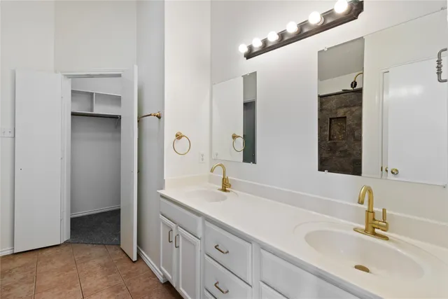 a bathroom with a double vanity sink a mirror and shower
