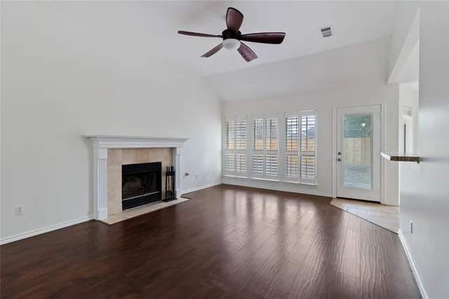 a view of empty room with wooden floor fireplace and a window