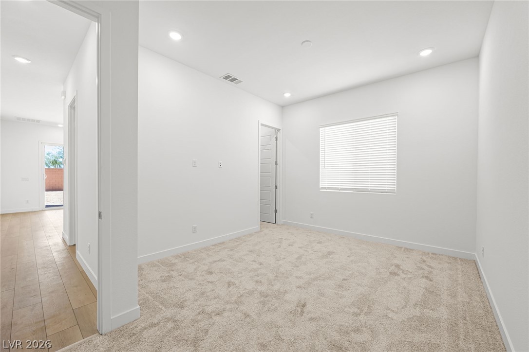 9983 Decano Ridge Street Las Vegas, NV 89141 - Photo 10 of 39 A quiet space with soft carpet, recessed lighting, and a view to the outdoors.