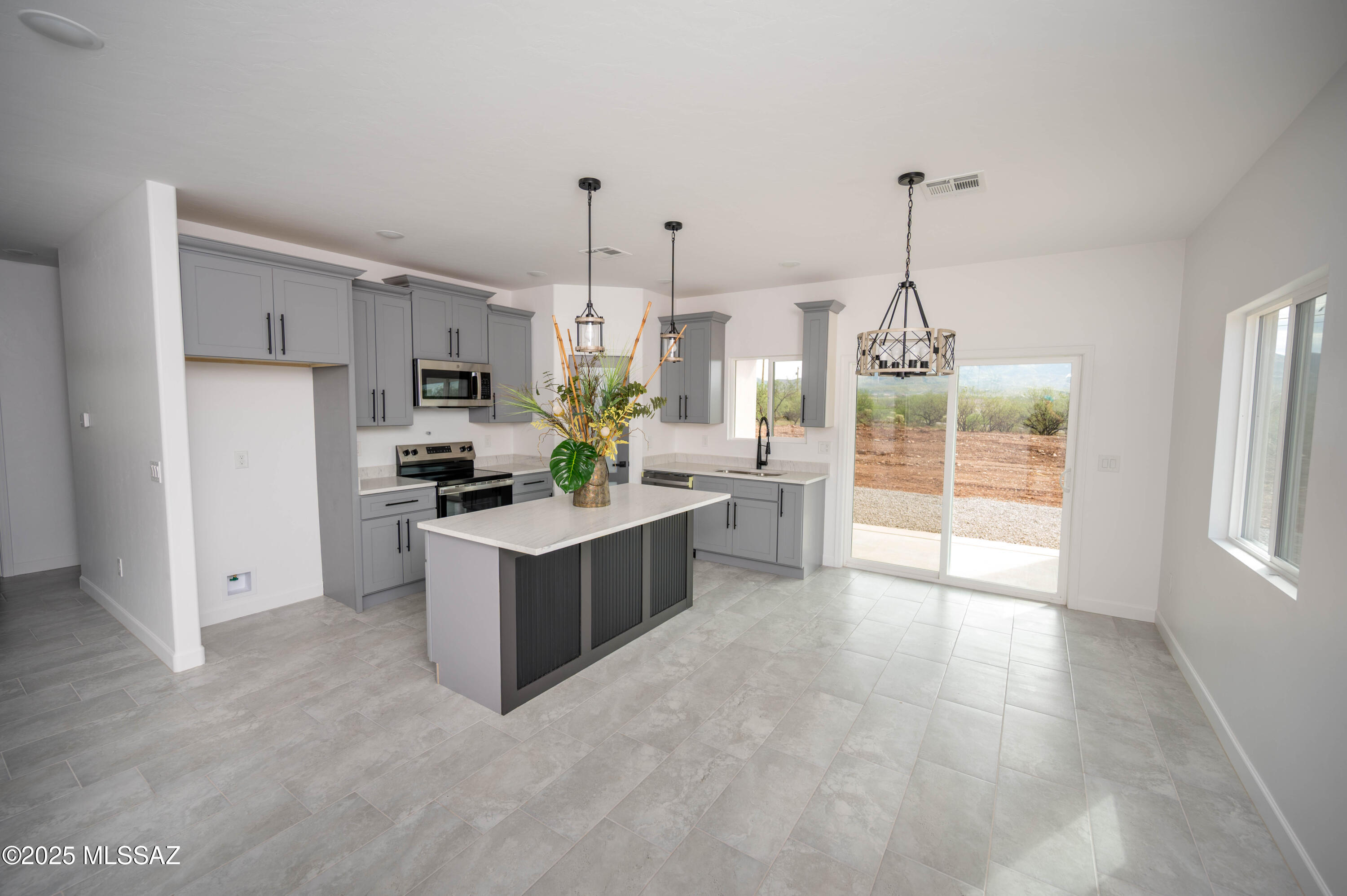 1781 Elder Court Rio Rico, AZ 85648 - Photo 39 of 50 a kitchen with stainless steel appliances kitchen island granite countertop a refrigerator a sink a stove and white cabinets