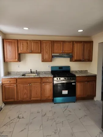 a kitchen with granite countertop a stove a sink dishwasher and a refrigerator