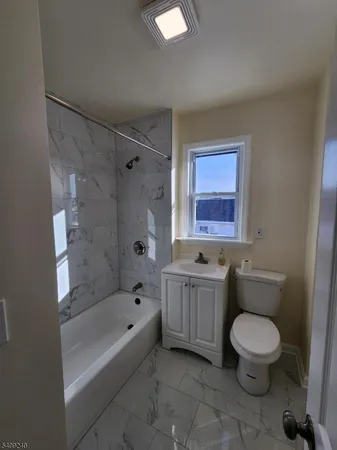 a bathroom with a granite countertop toilet a sink and bathtub