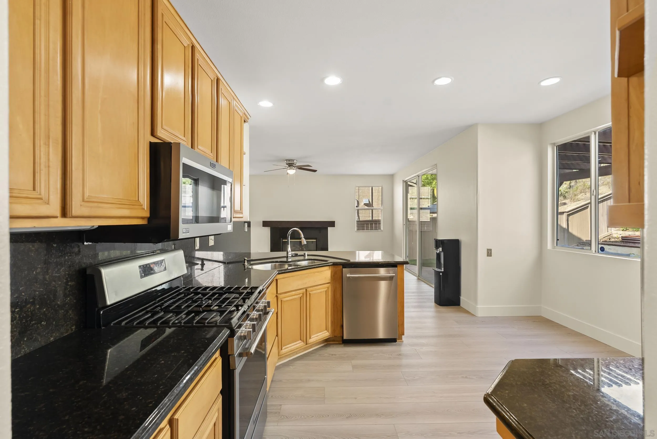 1405 Carneros Valley Street Chula Vista, CA 91913 - Photo 14 of 45 a kitchen with stainless steel appliances granite countertop a stove top oven a refrigerator a sink and dishwasher with wooden floor