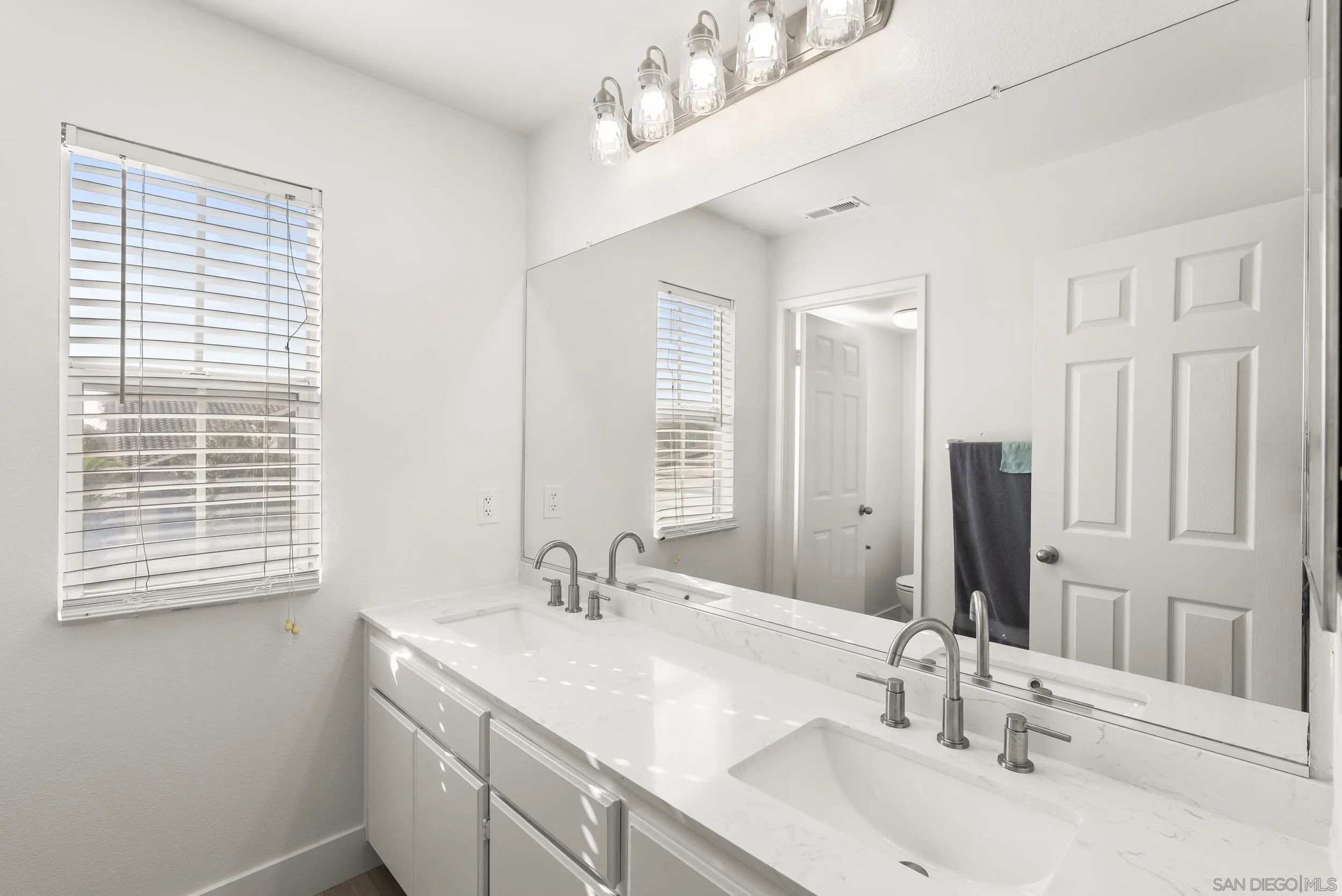 1405 Carneros Valley Street Chula Vista, CA 91913 - Photo 32 of 45 a bathroom with double vanity sinks and a mirror
