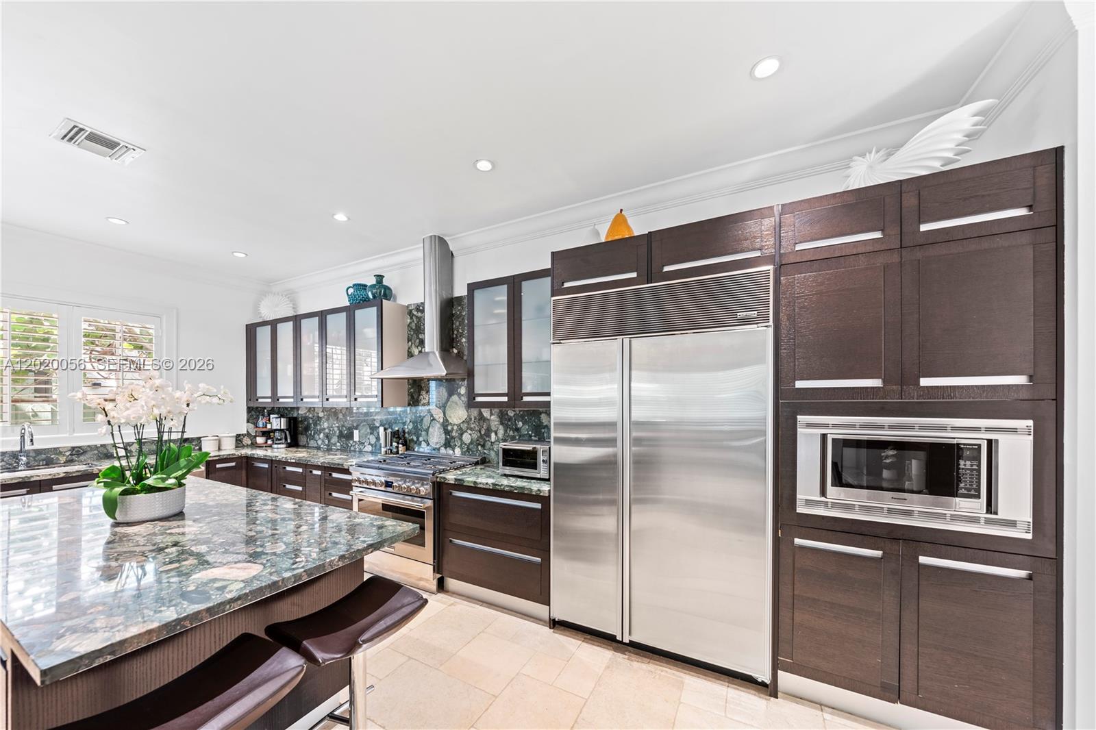 4196 Douglas Road Miami, FL 33133 - Photo 29 of 96 a kitchen with kitchen island a counter top space a stainless steel appliances and cabinets