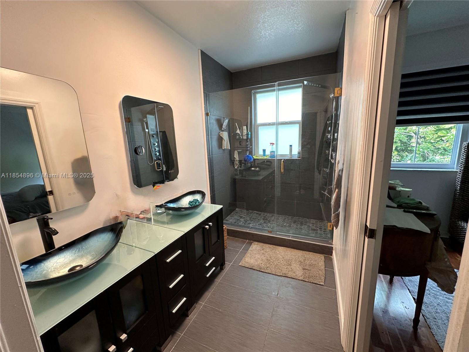 8908 Southwest 109th Avenue Miami, FL 33176 - Photo 20 of 28 a en suite bathroom with a double vanity sink and a mirror