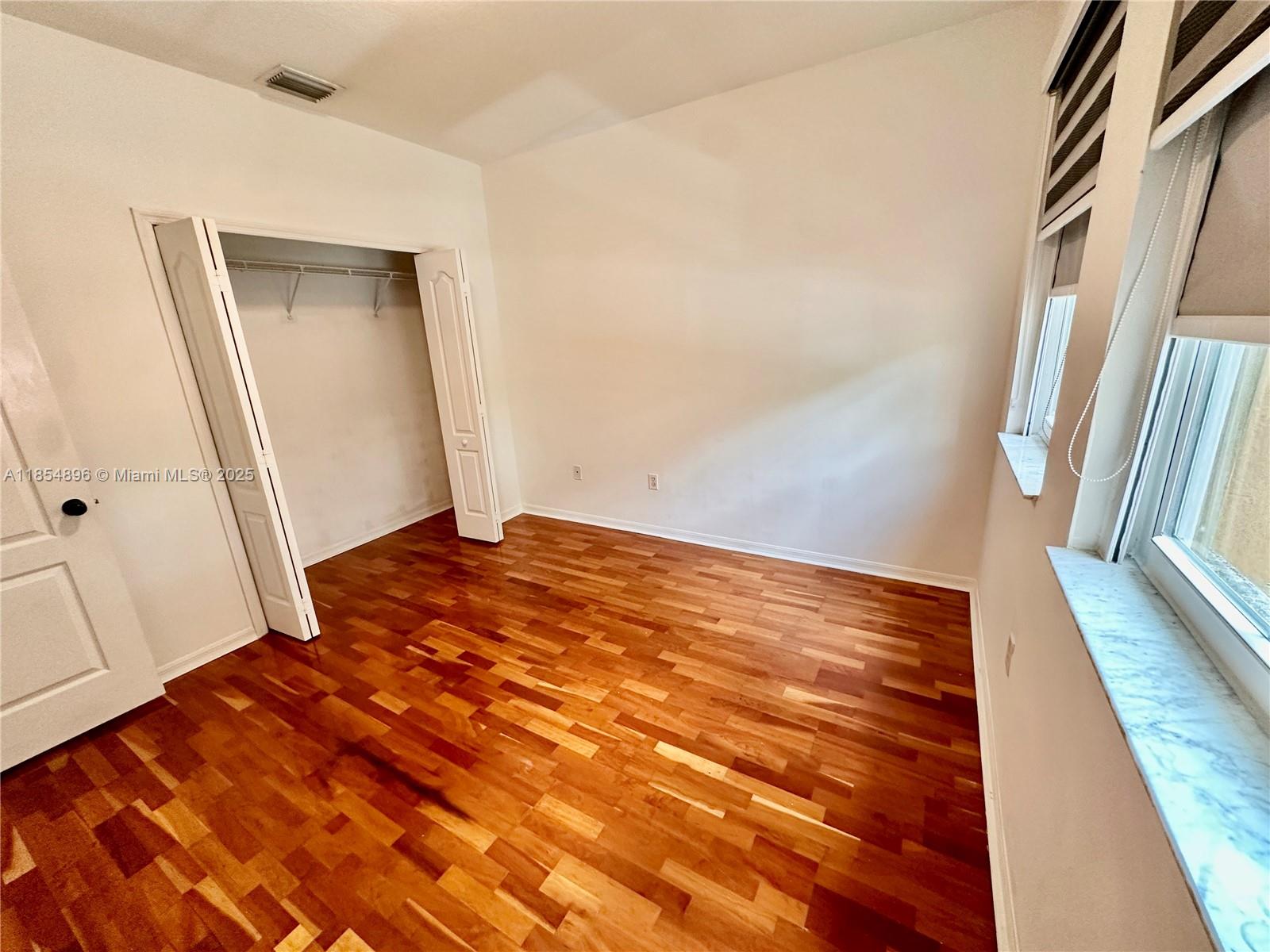 8908 Southwest 109th Avenue Miami, FL 33176 - Photo 25 of 28 a view of an empty room with wooden floor and a window