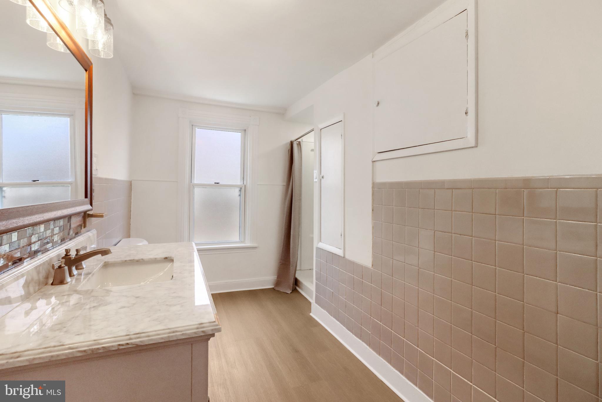 24369 West Main Street, Unit A Columbus, NJ 08022 - Photo 58 of 69 a bathroom with a granite countertop sink a toilet a mirror and shower