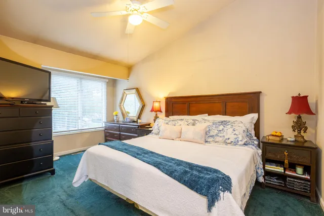 a bedroom with a bed and a flat tv screen on dresser