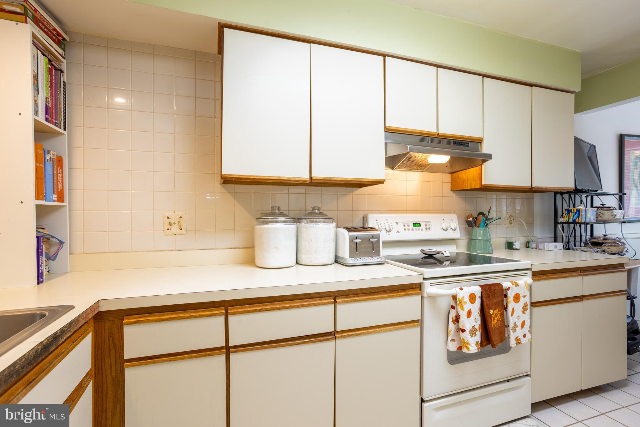 5065 Columbia Road, Unit 18 11 Columbia, MD 21044 - Photo 7 of 51 a kitchen with kitchen island white cabinets and white appliances