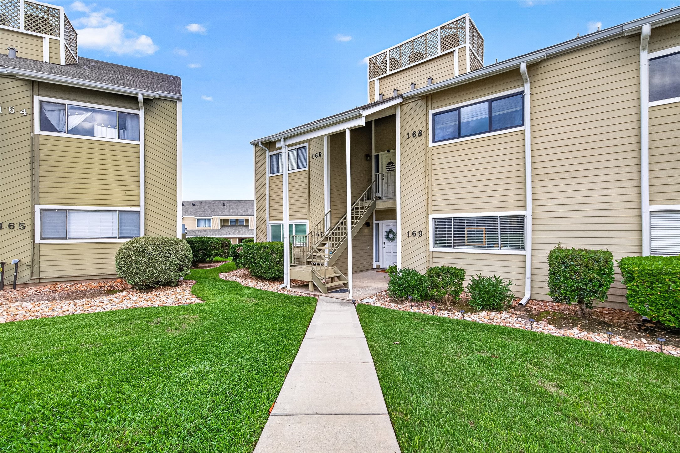 168 April Point Drive South, Unit 168 Conroe, TX 77356 - Photo 3 of 39 a front view of a house with a yard and garage