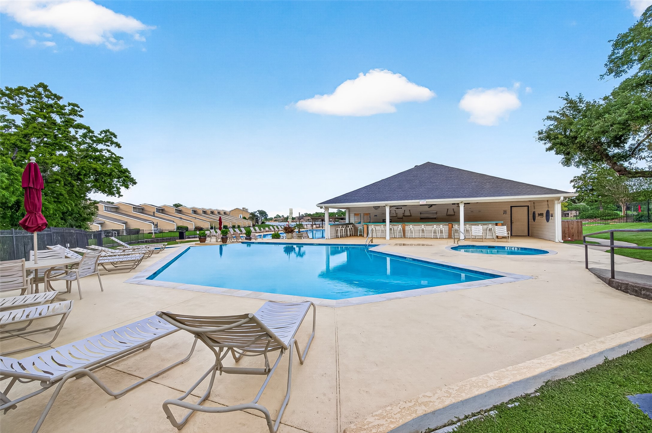 168 April Point Drive South, Unit 168 Conroe, TX 77356 - Photo 31 of 39 a view of a swimming pool with lawn chairs under an umbrella