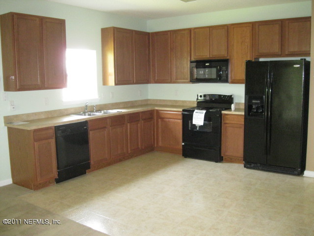 7284 Rampart Ridge Circle West Jacksonville, FL 32244 - Photo 4 of 9 a kitchen with stainless steel appliances granite countertop a refrigerator and a sink