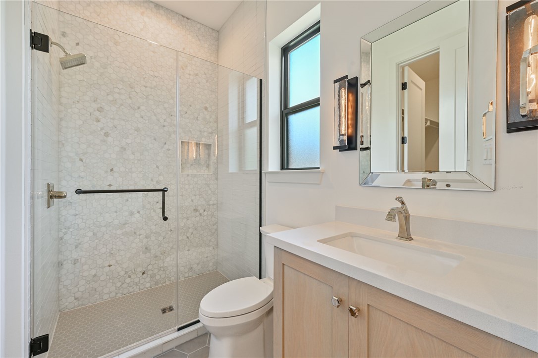5115 Inverness Drive Bryan, TX 77802 - Photo 19 of 28 Glass-enclosed shower featuring hexagonal tile, a built-in shower niche, and brushed nickel fixtures