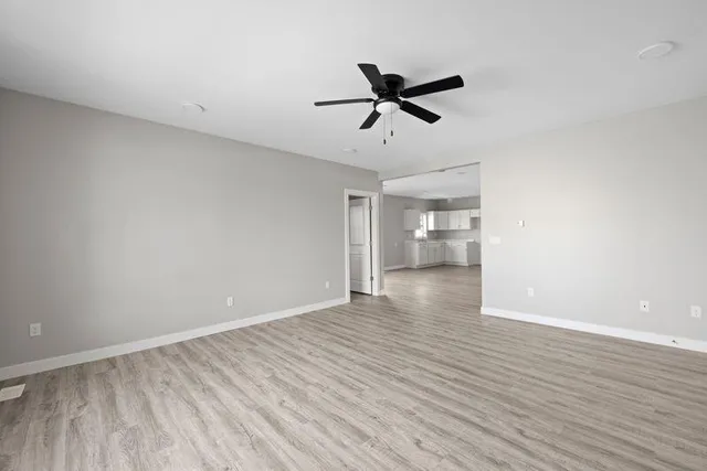 a view of empty room with wooden floor and window