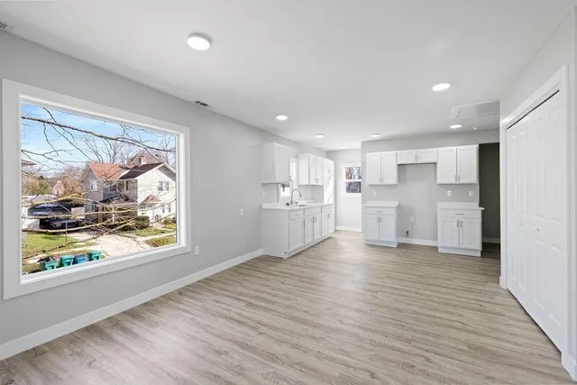 a view of a kitchen with wooden floor and a window