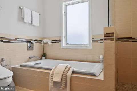 a bathroom with a granite countertop sink a toilet and bathtub