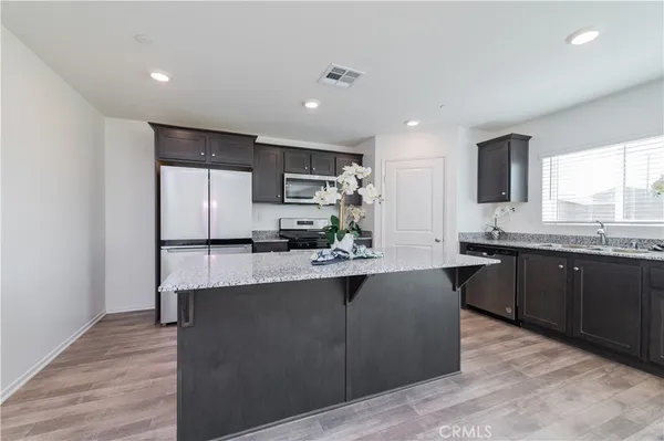 a kitchen with a center island and stainless steel appliances
