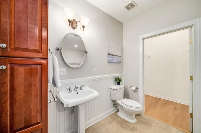 a bathroom with a toilet a sink and a mirror