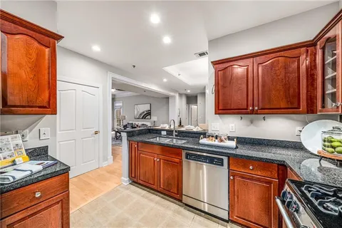 a kitchen with granite countertop wooden cabinets and stainless steel appliances