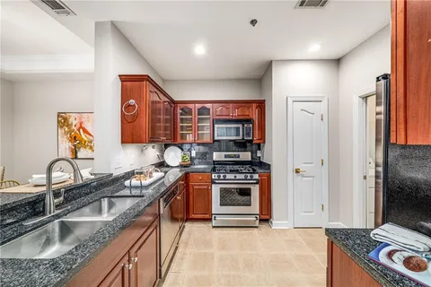 a kitchen with stainless steel appliances granite countertop a sink stove and refrigerator