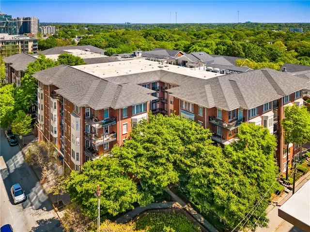 a view of a large building with a yard and plants