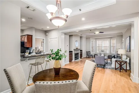 a living room with furniture dining table and a chandelier