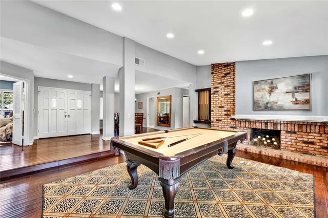 a room with furniture pool table and wooden floor