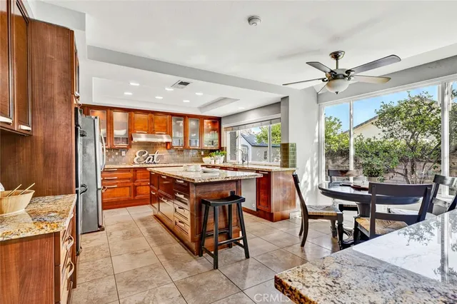 a open kitchen with stainless steel appliances granite countertop a stove and a dining table chair