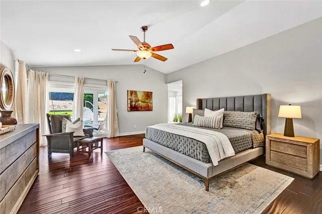 a spacious bedroom with a bed and wooden floor