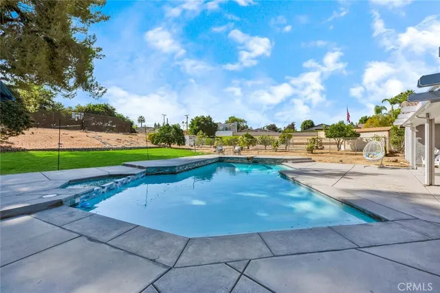 a view of a yard with swimming pool and green space