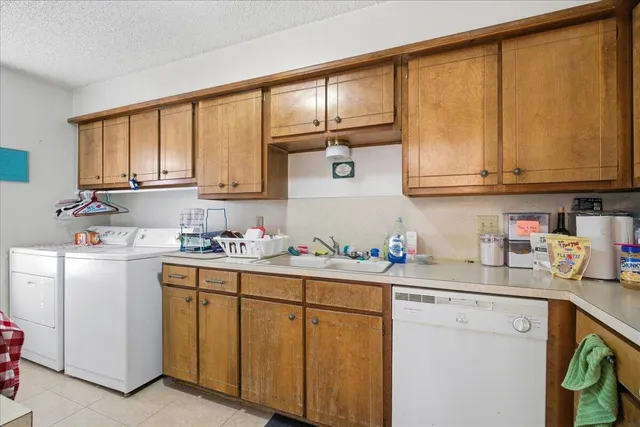 a utility room with fridge dryer and washer