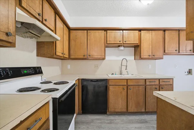 a kitchen with stainless steel appliances granite countertop a stove and a refrigerator