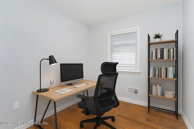 a view of a workspace with furniture and a book shelf