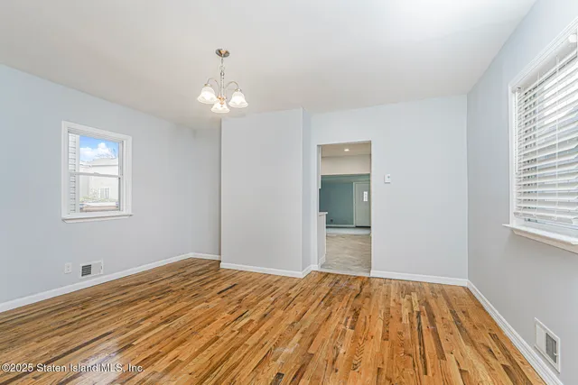 a view of a livingroom with wooden floor and a window