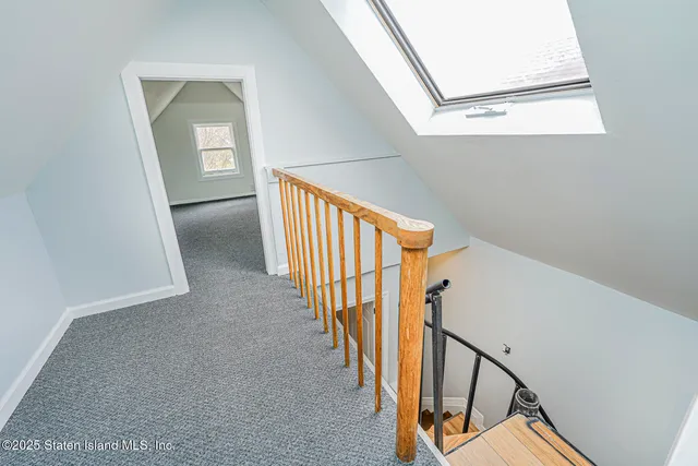 a view of staircase with railing and white walls