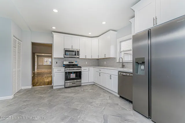 a kitchen with stainless steel appliances granite countertop a refrigerator and a stove