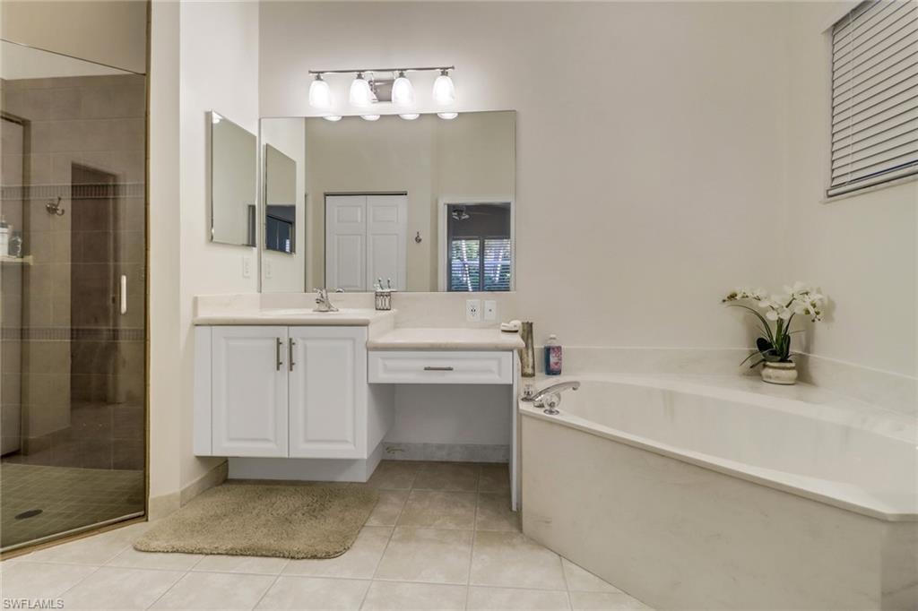9146 Springview Loop Estero, FL 33928 - Photo 16 of 49 a bathroom with a tub sink and mirror