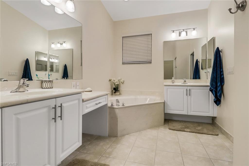 9146 Springview Loop Estero, FL 33928 - Photo 17 of 49 a bathroom with a tub sink and mirror