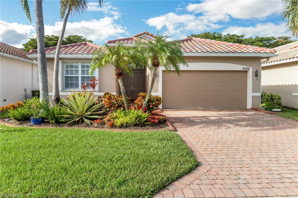 9146 Springview Loop Estero, FL 33928 - Photo 2 of 49 a front view of a house with a yard and potted plants
