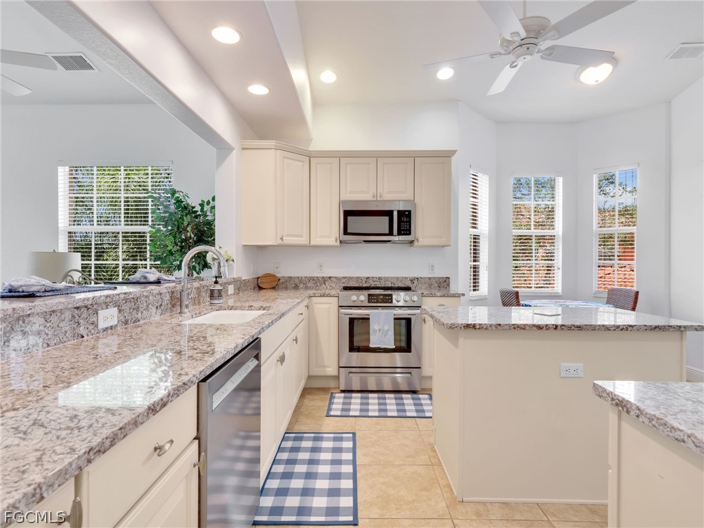 6422 Legacy Circle, Unit 704 Naples, FL 34113 - Photo 14 of 49 a kitchen with stainless steel appliances granite countertop a sink stove and cabinets